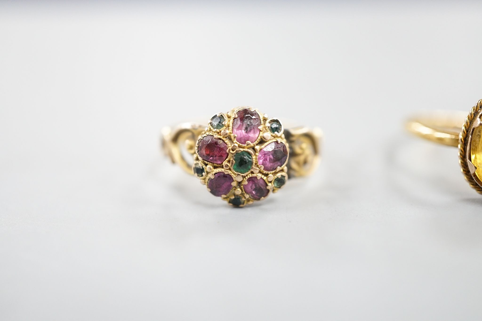 A late Victorian 15ct gold and two colour garnet set cluster ring (a.f.), size N, gross 2.2 grams, two other yellow metal and gem set rings including 19th century, gross 4.4 grams and one other ring.